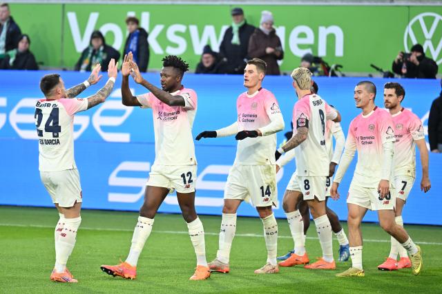 22 November 2025, Wolfsburg: Bayer Leverkusen's Edmond Tapsoba celebrates scoring his side's second goal with teammates during the German Bundesliga soccer match between VfL Wolfsburg and Bayer Leverkusen at the Volkswagen Arena. Photo: Swen Pförtner/dpa - IMPORTANT NOTICE: DFL and DFB regulations prohibit any use of photographs as image sequences and/or quasi-video.