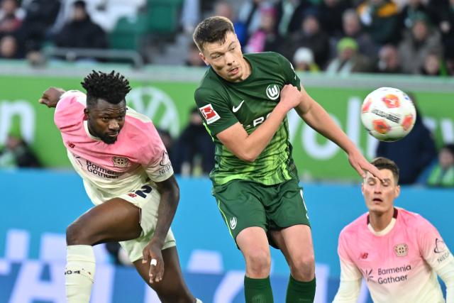 22 November 2025, Wolfsburg: Bayer Leverkusen's Edmond Tapsoba (L) heads to score his side's second goal during the German Bundesliga soccer match between VfL Wolfsburg and Bayer Leverkusen at the Volkswagen Arena. Photo: Swen Pförtner/dpa - IMPORTANT NOTICE: DFL and DFB regulations prohibit any use of photographs as image sequences and/or quasi-video.
