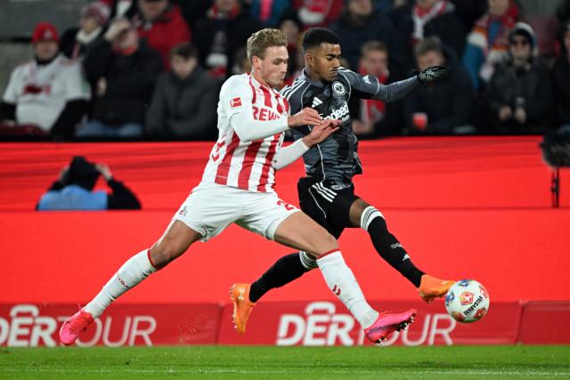 22 November 2025, North Rhine-Westphalia, Cologne: Cologne's Sebastian Sebulonsen and Frankfurt's Ansgar Knauff battle for the ball during the German Bundesliga soccer match between 1. FC Cologne and Eintracht Frankfurt at the RheinEnergieStadion. Photo: Federico Gambarini/dpa - IMPORTANT NOTE: In accordance with the regulations of the DFL German Football League and the DFB German Football Association, it is prohibited to utilize or have utilized photographs taken in the stadium and/or of the match in the form of sequential images and/or video-like photo series.