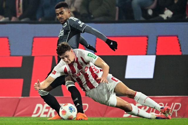 22 November 2025, North Rhine-Westphalia, Cologne: Cologne's Eric Martel and Eintracht Frankfurt's Ansgar Knauff battle for the ball during the German Bundesliga soccer match between 1. FC Cologne and Eintracht Frankfurt at the RheinEnergieStadion. Photo: Federico Gambarini/dpa - IMPORTANT NOTICE: DFL and DFB regulations prohibit any use of photographs as image sequences and/or quasi-video.
