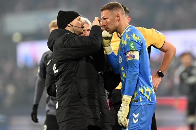 22 November 2025, North Rhine-Westphalia, Cologne: Cologne's goalkeeper Marvin Schwaebe receives medical attention on his eye during the German Bundesliga soccer match between 1. FC Cologne and Eintracht Frankfurt at the RheinEnergieStadion. Photo: Federico Gambarini/dpa - IMPORTANT NOTICE: DFL and DFB regulations prohibit any use of photographs as image sequences and/or quasi-video.