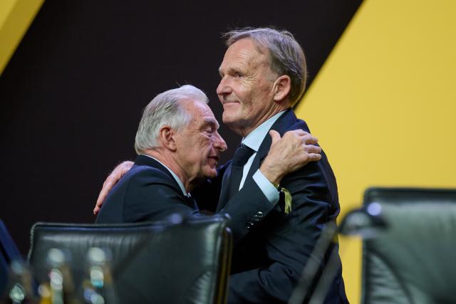 23 November 2025, North Rhine-Westphalia, Dortmund: Borussia Dortmund outgoing president Reinhold Lunow (l) embraces his designated successor, managing director Hans-Joachim Watzke, after his last speech as president during Borussia Dortmund general meeting. Photo: Bernd Thissen/dpa