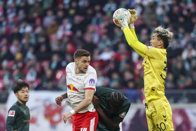 23 November 2025, Saxony, Leipzig: Werder Bremen goalkeeper Mio Backhaus (R) saves before Leipzig's Christoph Baumgartner (2nd L) during the German Bundesliga soccer match between RB Leipzig and Werder Bremen at Red Bull Arena. Photo: Jan Woitas/dpa - WICHTIGER HINWEIS: Gemäß den Vorgaben der DFL Deutsche Fußball Liga bzw. des DFB Deutscher Fußball-Bund ist es untersagt, in dem Stadion und/oder vom Spiel angefertigte Fotoaufnahmen in Form von Sequenzbildern und/oder videoähnlichen Fotostrecken zu verwerten bzw. verwerten zu lassen.