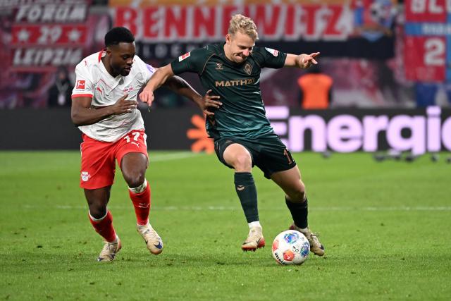 23 November 2025, Saxony, Leipzig: Leipzig's Ridle Baku (L) and Werder Bremen's Marco Gruell battle for the ball during the German Bundesliga soccer match between RB Leipzig and Werder Bremen at Red Bull Arena. Photo: Jennifer Brückner/dpa - WICHTIGER HINWEIS: Gemäß den Vorgaben der DFL Deutsche Fußball Liga bzw. des DFB Deutscher Fußball-Bund ist es untersagt, in dem Stadion und/oder vom Spiel angefertigte Fotoaufnahmen in Form von Sequenzbildern und/oder videoähnlichen Fotostrecken zu verwerten bzw. verwerten zu lassen.