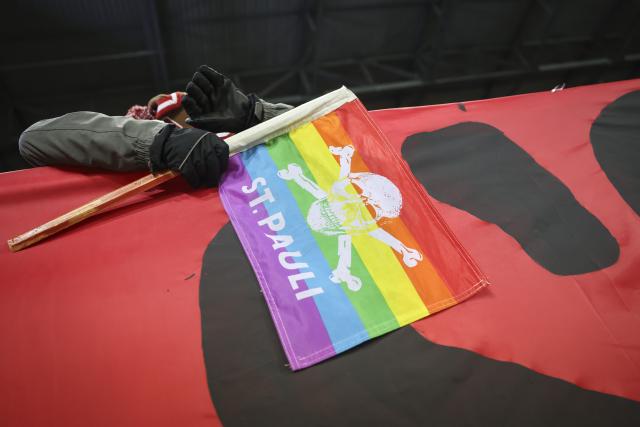 23 November 2025, Hamburg: A St. Pauli fan holda a flag during the German Bundesliga soccer match between FC St. Pauli and 1. FC Union Berlin at Millerntor Stadium. Photo: Christian Charisius/dpa - WICHTIGER HINWEIS: Gemäß den Vorgaben der DFL Deutsche Fußball Liga bzw. des DFB Deutscher Fußball-Bund ist es untersagt, in dem Stadion und/oder vom Spiel angefertigte Fotoaufnahmen in Form von Sequenzbildern und/oder videoähnlichen Fotostrecken zu verwerten bzw. verwerten zu lassen.