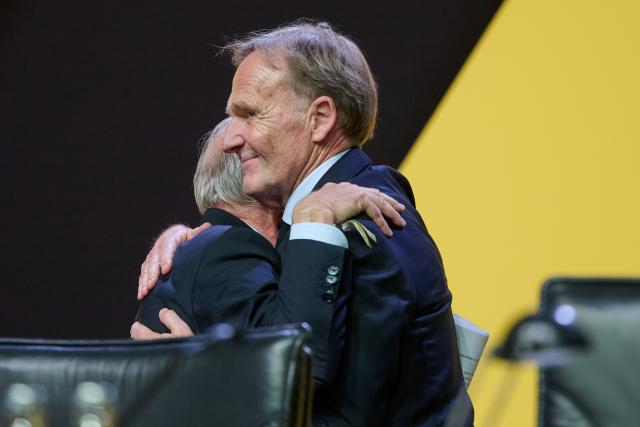 23 November 2025, North Rhine-Westphalia, Dortmund: Reinhold Lunow (L) embraces his designated successor Borussia Dortmund managing director Hans-Joachim Watzke, after his last speech as president during the Borussia Dortmund general meeting at the Westfalenhallen. Photo: Bernd Thissen/dpa