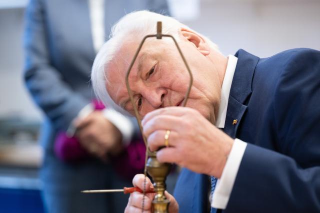 24 November 2025, Saxony, Hoyerswerda: German President Frank-Walter Steinmeier repairs a lamp at the Repair Café in the Kulturfabrik Hoyerswerda. Steinmeier is visiting the Kulturfabrik Hoyerswerda e.V. association to pay tribute to the importance of meeting places for social interaction. Photo: Sebastian Kahnert/dpa