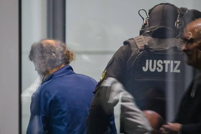 25 November 2025, Saxony-Anhalt, Magdeburg: Judicial officers lead the defendant Taleb al-Abdulmohsen (L) into the courtroom of the temporary court building at Magdeburg District Court. The public prosecutor's office is accusing the man from Saudi Arabia of 338 counts of attempted murder. On December 20, 2024, Taleb al-Abdulmohsen drove into a crowd of people at Magdeburg's Christmas market, killing 6 and injuring more than 300 people. Photo: Klaus-Dietmar Gabbert/dpa
