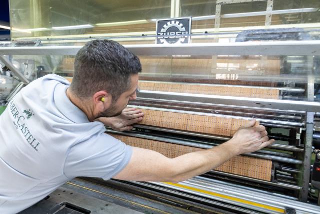 FILED - 24 November 2021, Bavaria, Stein: An employee of the stationery manufacturer Faber-Castell checks a press in the company's production facility. Stationery manufacturer Faber-Castell on Tuesday said it plans to cut around 130 jobs in Germany. Photo: Daniel Karmann/dpa