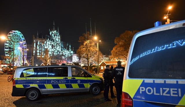 25 November 2025, Thuringia, Erfurt: Police officers stand on site as the 175th Erfurt Christmas Market opens on Cathedral Square. Around 150 decorated wooden huts offer Thuringian delicacies, Christmas ornaments, blueprint textiles, pottery, and Ore Mountain folk art. According to the city, last year's market attracted more than 1.2 million visitors. It is open until December 22. Photo: Martin Schutt/dpa