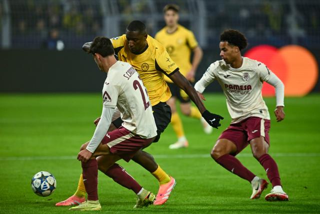 25 November 2025, North Rhine-Westphalia, Dortmund: Villarreal's Sergi Cardona (L) and Borussia Dortmund's Serhou Guirassy battle for the ballduring the UEFA Champions League soccer match between Borussia Dortmund and FC Villarreal at Signal Iduna Park. Photo: Bernd Thissen/dpa