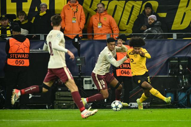 25 November 2025, North Rhine-Westphalia, Dortmund: Villarreal's Santiago Mourino and Borussia Dortmund's Karim Adeyemi (R) battle for the ball during the UEFA Champions League soccer match between Borussia Dortmund and FC Villarreal at Signal Iduna Park. Photo: Bernd Thissen/dpa