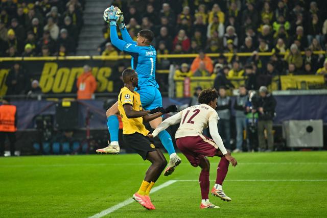 25 November 2025, North Rhine-Westphalia, Dortmund: Villarreal goalkeeper Luiz Junior (C) saves the ball next to Borussia Dortmund's Serhou Guirassy (L) and Villarreal's Renato Veiga during the UEFA Champions League soccer match between Borussia Dortmund and FC Villarreal at Signal Iduna Park. Photo: Bernd Thissen/dpa