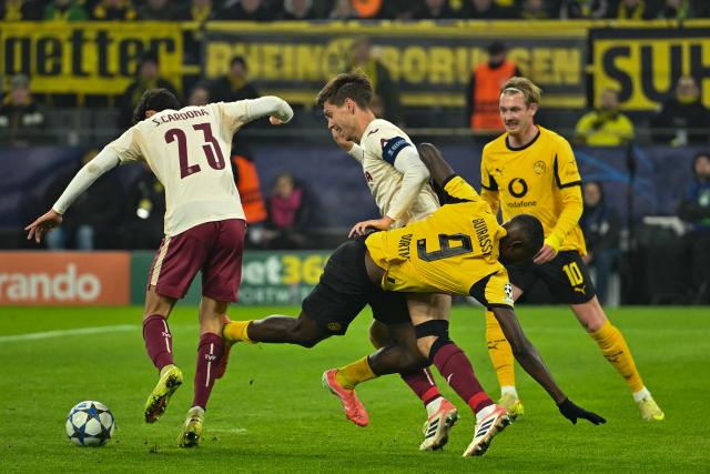 25 November 2025, North Rhine-Westphalia, Dortmund: Borussia Dortmund's Serhou Guirassy (R) and Villarreal's Sergi Cardona (L) and Juan Foyth battle for the ball during the UEFA Champions League soccer match between Borussia Dortmund and FC Villarreal at Signal Iduna Park. Photo: Bernd Thissen/dpa