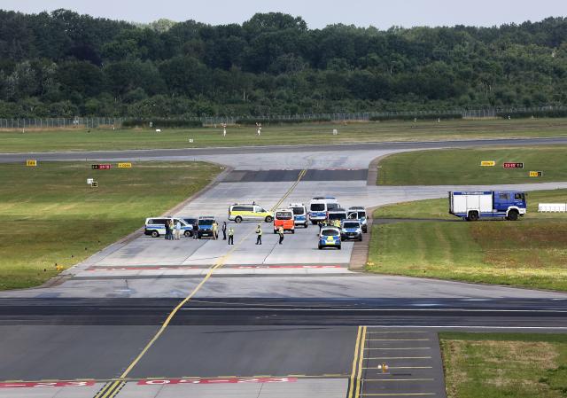 FILED - 13 July 2023, Hamburg: Police officers stand on a tarmac at Hamburg Airport. Ten activists from the climate action group Last Generation must pay more than ·400,000 ($463,208) to the airline Eurowings due to a blockade of Hamburg Airport. Photo: Bodo Marks/dpa