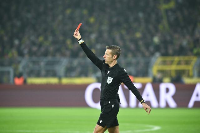 25 November 2025, North Rhine-Westphalia, Dortmund: Referee Davide Massa shows Villarreal's Foyth (not pictured) the red card during the UEFA Champions League soccer match between Borussia Dortmund and FC Villarreal at Signal Iduna Park. Photo: Bernd Thissen/dpa