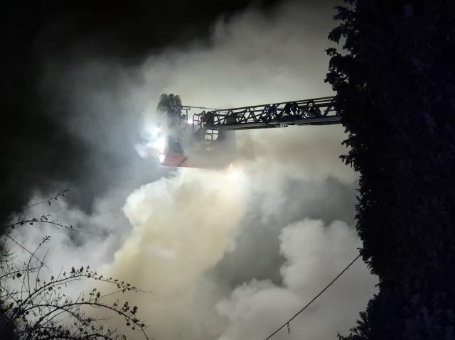 25 November 2025, North Rhine-Westphalia, Cologne: Firefighters extinguish the fire in a residential building from a turntable ladder. A terraced house in the German city of Cologne with illegal fireworks inside was completely engulfed in flames, according to the fire brigade. Photo: Sascha Thelen/dpa