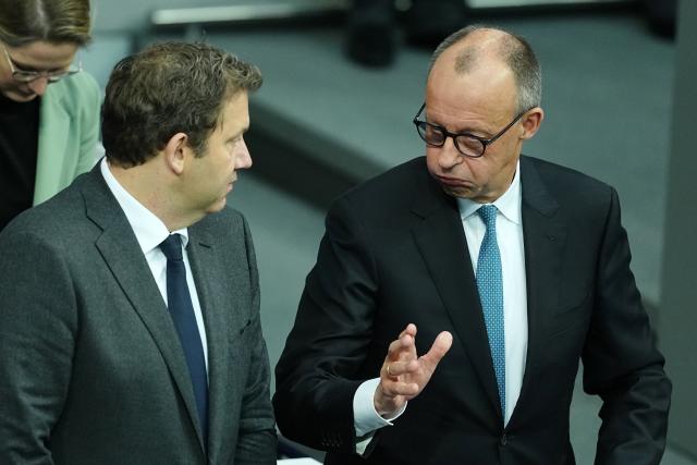 26 November 2025, Berlin: Lars Klingbeil (L), German Minister of Finance, Vice-Chancellor and   Friedrich Merz, German Chancellor  speak before the general debate in the Bundestag. The debates on the budget of the Chancellor's Office are traditionally used as a general debate on the policies of the Federal Government. Photo: Kay Nietfeld/dpa
