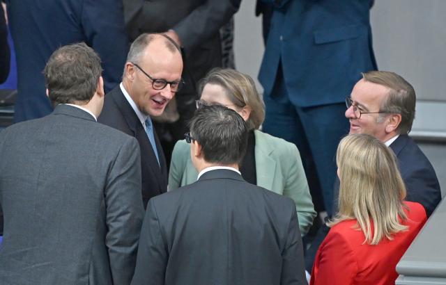 26 November 2025, Berlin: German Chancellor Friedrich Merz (2-L) talks to colleagues before the general debate on the budget in the Bundestag. The debates on the budget of the Chancellor's Office are traditionally used as a general debate on the policies of the Federal Government. Photo: Elise Schu/dpa