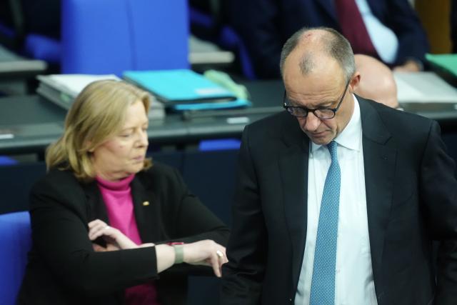 26 November 2025, Berlin: German Chancellor Friedrich Merz (R) walks past Baerbel Bas, German Minister of Labor and Social Affairs, during the general debate in the Bundestag on the budget. The debates on the budget of the Chancellor's Office are traditionally used as a general debate on the policies of the Federal Government. Photo: Kay Nietfeld/dpa
