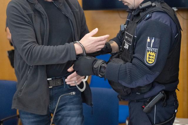 FILED - 28 July 2025, Baden-Württemberg, Heilbronn: The defendant (L) is being cuffed druing the trial for killing two colleagues at a factory in south-western Germany earlier this year. Court has found him guilty and sentenced him to life imprisonment. Photo: -/dpa - ACHTUNG: Person(en) wurde(n) aus rechtlichen Gründen gepixelt