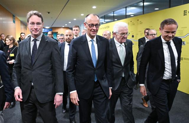 26 November 2025, Baden-Württemberg, Stuttgart: (L-R) Ola Kaellenius, CEO of Mercedes-Benz Group, German Chancellor Friedrich Merz, Winfried Kretschmann, Minister President of Baden-Wuerttemberg, and Oliver Blume, CEO of Volkswagen AG, walk together into the conference room for the annual Automotive Industry Strategy Dialogue. Photo: Bernd Weißbrod/dpa-Pool/dpa