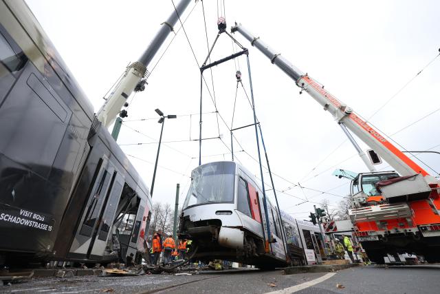 26 November 2025, North Rhine-Westphalia, Duesseldorf: A damaged streetcar is lifted by a crane. 13 people were injured when a streetcar derailed in Duesseldorf. Photo: David Young/dpa