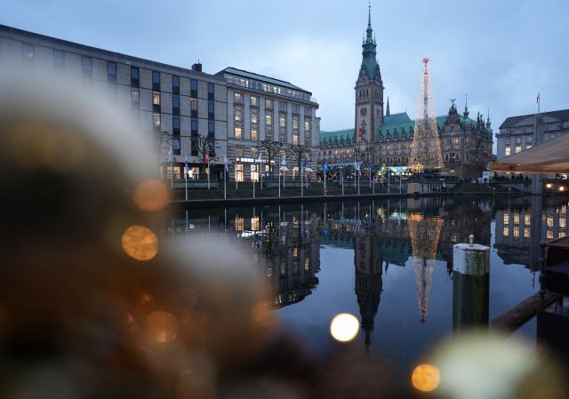 26 November 2025, Hamburg: The town hall tower and the huge light installation in the shape of a Christmas tree are reflected on the water surface of the Kleine Alster in the city center. Photo: Marcus Brandt/dpa