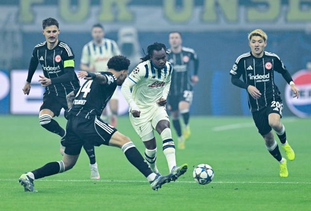 26 November 2025, Hesse, Frankfurt/Main: Eintracht Frankfurt's Nnamdi Collins (L) and Atalanta's Ademola Lookman battle for the ball during the UEFA Champions League soccer match between Eintracht Frankfurt and Atalanta Bergamo at Deutsche Bank Park. Photo: Uwe Anspach/dpa