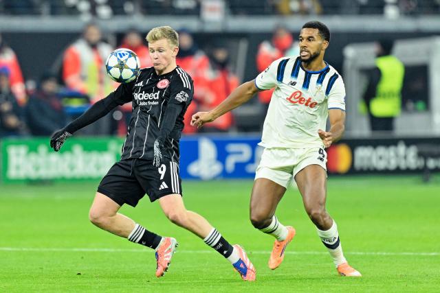26 November 2025, Hesse, Frankfurt/Main: Eintracht Frankfurt's Jonathan Burkardt (L) and Atalanta's Isak Hien battle for the ball during the UEFA Champions League soccer match between Eintracht Frankfurt and Atalanta Bergamo at Deutsche Bank Park. Photo: Uwe Anspach/dpa