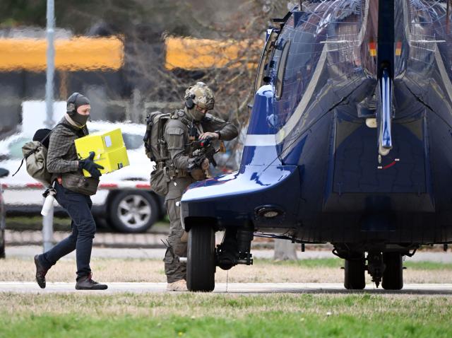 28 November 2025, Baden-Württemberg, Karlsruhe: Two police officers walk to a helicopter in a government center. A suspected mastermind of the attacks on the Nord Stream gas pipelines was previously brought before the investigating judge of the Federal Court of Justice (BGH) in Karlsruhe for a detention hearing. Photo: Uli Deck/dpa