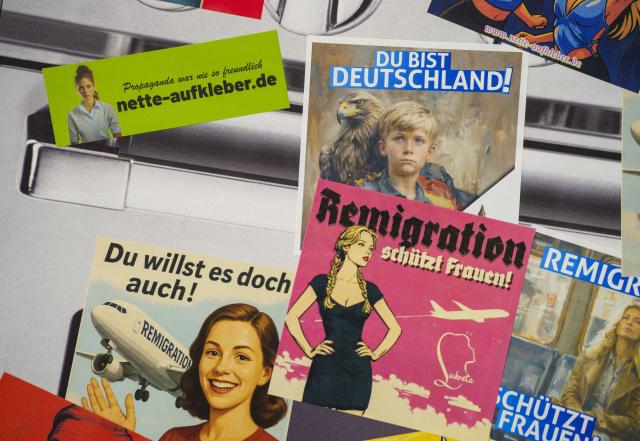 29 November 2025, Hesse, Giessen: At the founding event of the AfD youth organization, stickers are offered with the slogan "Remigration protects women!", among others. The predecessor organization "Junge Alternative", which was classified as right-wing extremist, had dissolved itself. The two federal co-chairs are also due to speak at the founding event in the Hessenhallen. Photo: Andreas Arnold/dpa