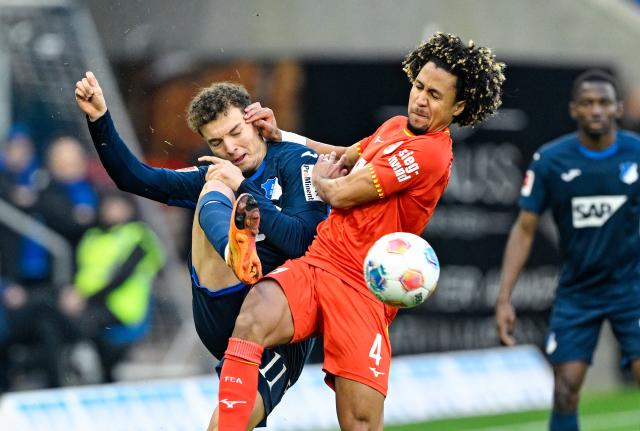 29 November 2025, Baden-Wuerttemberg, Sinsheim: Hoffenheim's Fisnik Asllani (L) and Augsburg's Han-Noah Massengo battle for the ball during the German Bundesliga soccer match between TSG 1899 Hoffenheim and FC Augsburg at PreZero Arena. Photo: Uwe Anspach/dpa - WICHTIGER HINWEIS: Gemäß den Vorgaben der DFL Deutsche Fußball Liga bzw. des DFB Deutscher Fußball-Bund ist es untersagt, in dem Stadion und/oder vom Spiel angefertigte Fotoaufnahmen in Form von Sequenzbildern und/oder videoähnlichen Fotostrecken zu verwerten bzw. verwerten zu lassen.