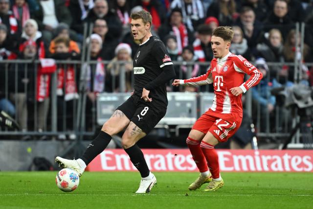 29 November 2025, Bavaria, Munich: St. Pauli's Eric Smith (L) and Bayern Munich's Lennart Karl battle for the ball during the German Bundesliga soccer match between Bayern Munich and FC St. Pauli at Allianz Arena. Photo: Sven Hoppe/dpa - IMPORTANT NOTICE: DFL and DFB regulations prohibit any use of photographs as image sequences and/or quasi-video.