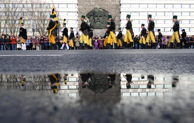 29 November 2025, Saxony, Chemnitz: Participants in a mountain parade pass in front of the Karl Marx Monument in their traditional costumes during the closing of the Capital of Culture Year 2025 in Chemnitz. Photo: Hendrik Schmidt/dpa