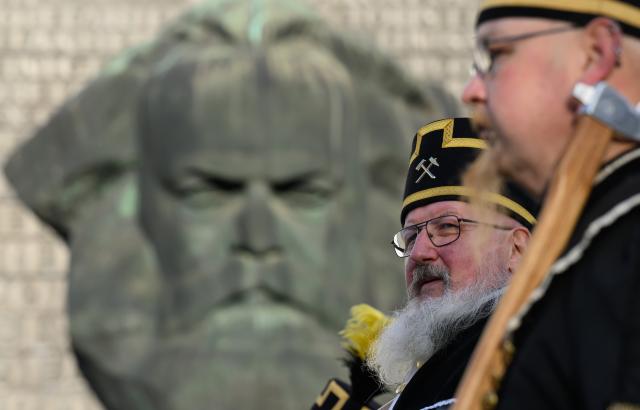 29 November 2025, Saxony, Chemnitz: Participants in a mountain parade pass in front of the Karl Marx Monument in their traditional costumes during the closing of the Capital of Culture Year 2025 in Chemnitz. Photo: Hendrik Schmidt/dpa