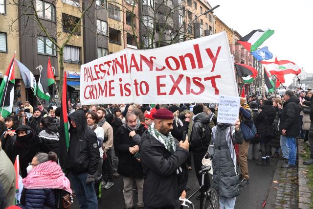 29 November 2025, Berlin: People holding flags and banners during the pro-Palestinian demonstration "Stop the complicity. Sanctions now!" march towards Kottbuser Tor. Photo: Paul Zinken/dpa