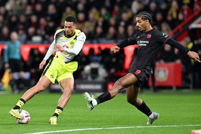 29 November 2025, North Rhine-Westphalia, Leverkusen: Bayer Leverkusen's Loic Bade (R) and Borussia Dortmund's Felix Nmecha battle for the ball during the German Bundesliga soccer match between Bayer Leverkusen and Borussia Dortmund at BayArena. Photo: Federico Gambarini/dpa - WICHTIGER HINWEIS: Gemäß den Vorgaben der DFL Deutsche Fußball Liga bzw. des DFB Deutscher Fußball-Bund ist es untersagt, in dem Stadion und/oder vom Spiel angefertigte Fotoaufnahmen in Form von Sequenzbildern und/oder videoähnlichen Fotostrecken zu verwerten bzw. verwerten zu lassen.