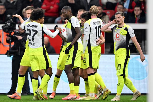29 November 2025, North Rhine-Westphalia, Leverkusen: Dortmund players celebrate their side's first goal during the German Bundesliga soccer match between Bayer Leverkusen and Borussia Dortmund at BayArena. Photo: Federico Gambarini/dpa - WICHTIGER HINWEIS: Gemäß den Vorgaben der DFL Deutsche Fußball Liga bzw. des DFB Deutscher Fußball-Bund ist es untersagt, in dem Stadion und/oder vom Spiel angefertigte Fotoaufnahmen in Form von Sequenzbildern und/oder videoähnlichen Fotostrecken zu verwerten bzw. verwerten zu lassen.