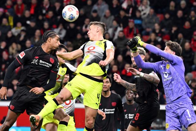 29 November 2025, North Rhine-Westphalia, Leverkusen: Bayer Leverkusen's Loic Bade (L) and Borussia Dortmund's Nico Schlotterbeck battle for the ball during the German Bundesliga soccer match between Bayer Leverkusen and Borussia Dortmund at BayArena. Photo: Federico Gambarini/dpa - WICHTIGER HINWEIS: Gemäß den Vorgaben der DFL Deutsche Fußball Liga bzw. des DFB Deutscher Fußball-Bund ist es untersagt, in dem Stadion und/oder vom Spiel angefertigte Fotoaufnahmen in Form von Sequenzbildern und/oder videoähnlichen Fotostrecken zu verwerten bzw. verwerten zu lassen.