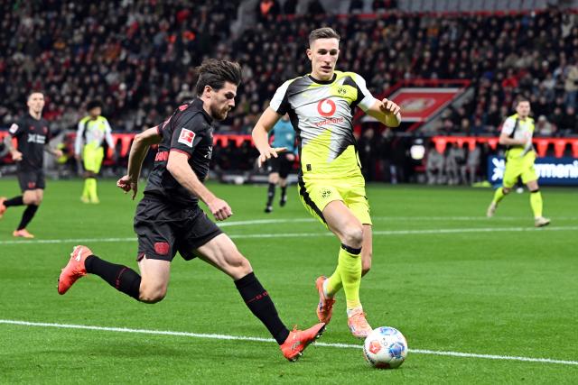 29 November 2025, North Rhine-Westphalia, Leverkusen: Bayer Leverkusen's Jonas Hofmann (L) and Borussia Dortmund's Nico Schlotterbeck battle for the ball during the German Bundesliga soccer match between Bayer Leverkusen and Borussia Dortmund at BayArena. Photo: Federico Gambarini/dpa - WICHTIGER HINWEIS: Gemäß den Vorgaben der DFL Deutsche Fußball Liga bzw. des DFB Deutscher Fußball-Bund ist es untersagt, in dem Stadion und/oder vom Spiel angefertigte Fotoaufnahmen in Form von Sequenzbildern und/oder videoähnlichen Fotostrecken zu verwerten bzw. verwerten zu lassen.