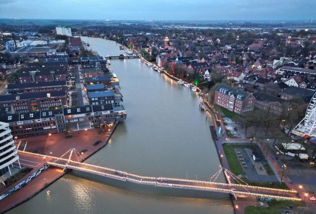 30 November 2025, Lower Saxony, Leer: An aerial view shows the port of Leer lit up for Christmas. The Nessebrücke bridge has been shining in festive splendor since November 24, 2025, as part of new Christmas lighting that also includes the town hall bridge and the harbor promenade. The bridge is illuminated for the first time to mark the opening of the 2025 Christmas market. Photo: Lars Penning/dpa