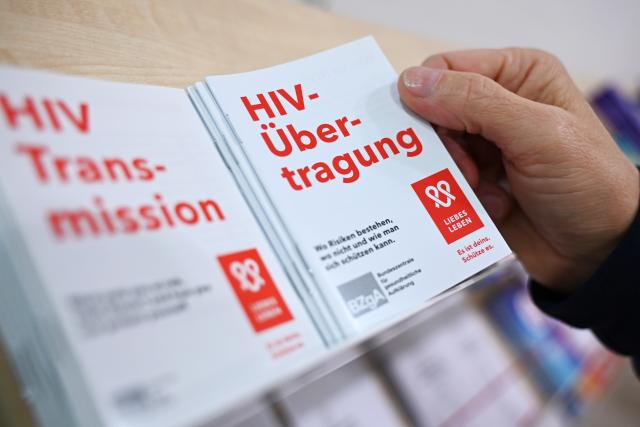PRODUCTION - 27 November 2025, Berlin: At the Berliner aids-hilfe e.V., a man reaches for an information brochure on HIV transmission. World AIDS Day is observed annually on December 1. Photo: Elisa Schu/dpa