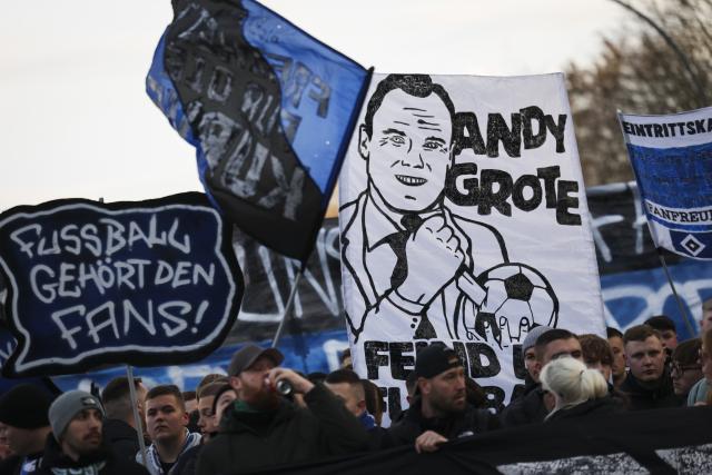 30 November 2025, Hamburg: Hamburger SV fans march with protest banners towards the Volksparkstadion at the German Bundesliga soccer match between Hamburger SV and VfB Stuttgart. Photo: Christian Charisius/dpa - IMPORTANT NOTE: In accordance with the regulations of the DFL German Football League and the DFB German Football Association, it is prohibited to utilize or have utilized photographs taken in the stadium and/or of the match in the form of sequential images and/or video-like photo series.
