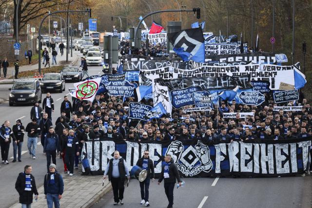 30 November 2025, Hamburg: Hamburger SV fans march with protest banners towards the Volksparkstadion at the German Bundesliga soccer match between Hamburger SV and VfB Stuttgart. Photo: Christian Charisius/dpa - IMPORTANT NOTICE: DFL and DFB regulations prohibit any use of photographs as image sequences and/or quasi-video.