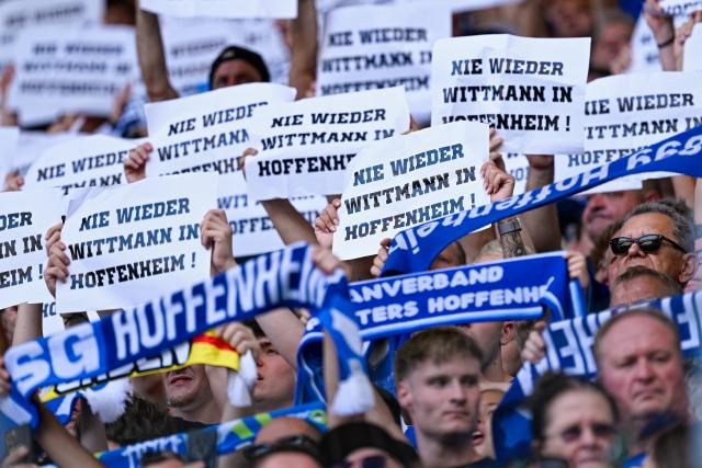 FILED - 20 September 2025, Sinsheim: Hoffenheim fans hold up notes with the inscription "Never again Wittmann in Hoffenheim! during the German Bundesliga soccer match between 1899 Hoffenheim and FC Bayern Munichat the PreZero Arena.  Hoffenheim will not appeal a court ruling to nullify a stadium ban imposed by the Bundesliga club against agent Roger Wittmann and another member of the Rogon agency. Photo: Uwe Anspach/dpa - WICHTIGER HINWEIS: Gemäß den Vorgaben der DFL Deutsche Fußball Liga bzw. des DFB Deutscher Fußball-Bund ist es untersagt, in dem Stadion und/oder vom Spiel angefertigte Fotoaufnahmen in Form von Sequenzbildern und/oder videoähnlichen Fotostrecken zu verwerten bzw. verwerten zu lassen.