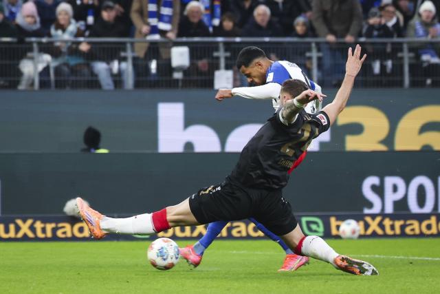 30 November 2025, Hamburg: Hamburger's Robert Glatzel scores his side's first goal against Stuttgart's Jeff Chabot during the German Bundesliga soccer match between Hamburger SV and VfB Stuttgart at the Volksparkstadion. Photo: Christian Charisius/dpa - IMPORTANT NOTICE: DFL and DFB regulations prohibit any use of photographs as image sequences and/or quasi-video.