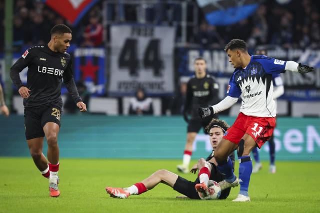 30 November 2025, Hamburg: Hamburger's Ransford Koenigsdoerffer and Stuttgart's Ameen Al-Dakhil battle for the ball during the German Bundesliga soccer match between Hamburger SV and VfB Stuttgart at the Volksparkstadion. Photo: Christian Charisius/dpa - IMPORTANT NOTICE: DFL and DFB regulations prohibit any use of photographs as image sequences and/or quasi-video.