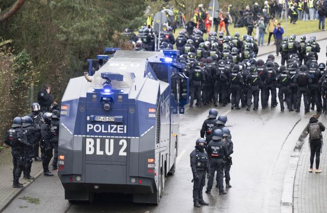 29 November 2025, Hesse, Gießen: Police officers and a water cannon block access for demonstrators near the assembly hall in Giessen. Several thousand demonstrators protested against the founding of a new AfD youth organization on Saturday. Its predecessor, Junge Alternative, which had been classified as right-wing extremist, had dissolved itself. Photo: Boris Roessler/dpa