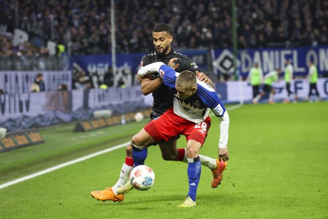 30 November 2025, Hamburg: Hamburger's Miro Muheim and Stuttgart's Josha Vagnoman (L) battle for the ball during the German Bundesliga soccer match between Hamburger SV and VfB Stuttgart at the Volksparkstadion. Photo: Christian Charisius/dpa - IMPORTANT NOTICE: DFL and DFB regulations prohibit any use of photographs as image sequences and/or quasi-video.